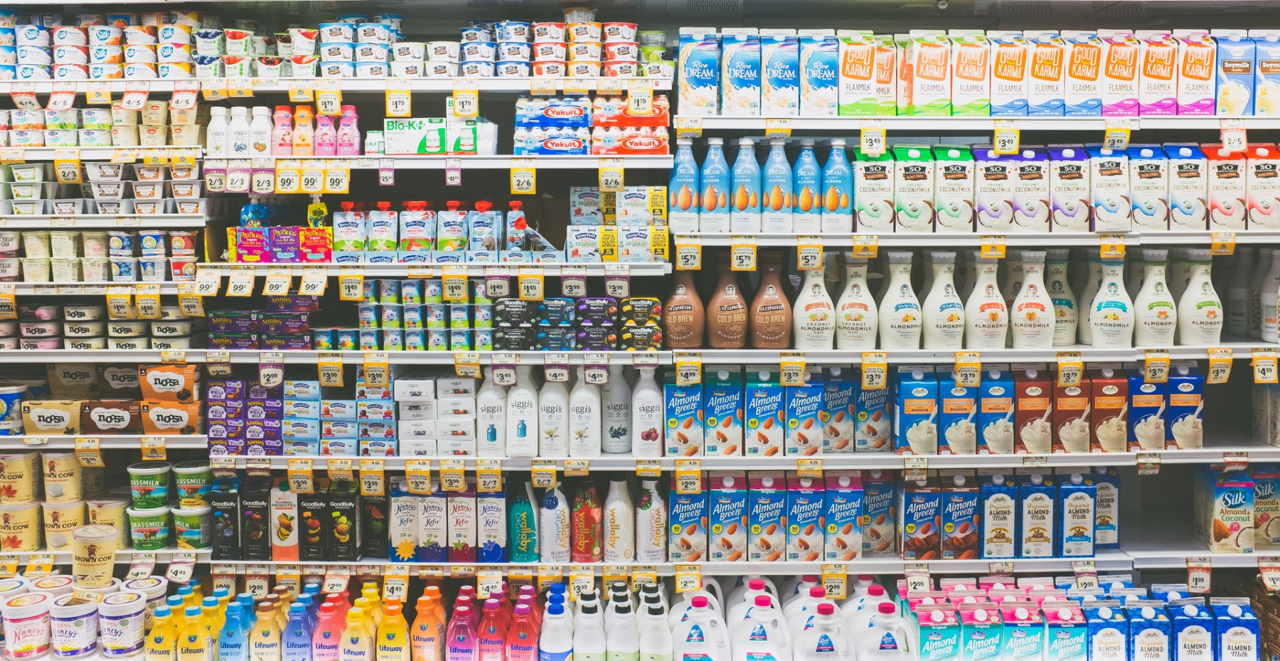 A selection of dairy and non-dairy products in a supermarket fridge