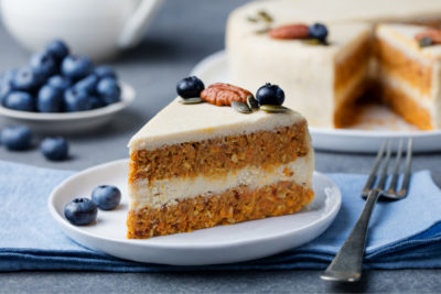 Vegan carrot cake on a table with a fork. Our vegan baking guide will help create tasty vegan bakes.