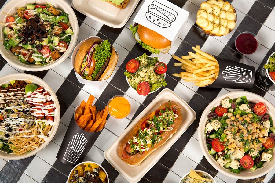 Flatlay of vegan restaurant foods. Eating out as a vegan is easier than it seems.