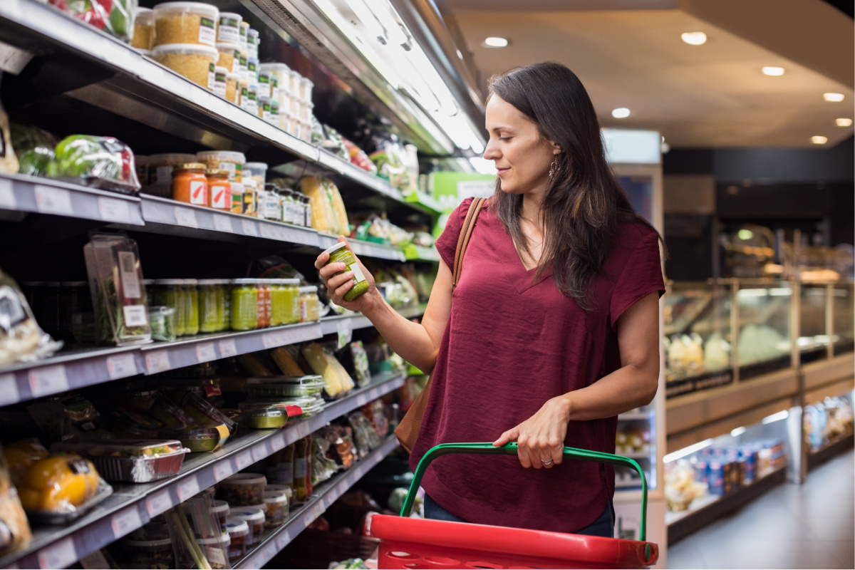 Woman holding shopping basket and choose a product in supermarket.