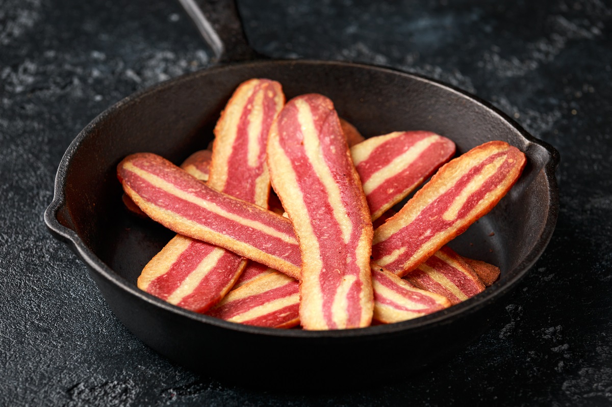 Fried crunchy plant based vegan Bacon pieces in a cast iron skillet