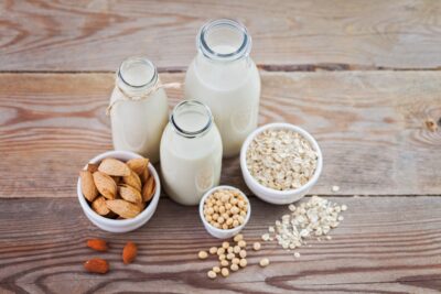 A selection of plant milks on a wooden table